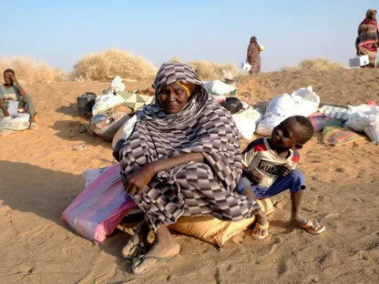 امرأة سودانية نازحة تجلس مع طفلها أثناء انتظارهما الإذن بدخول أحد مخيمات مدينة الدبة بعد سيطرة "قوات الدعم السريع" على الفاشر- 13 نوفمبر 2025 - Reuters