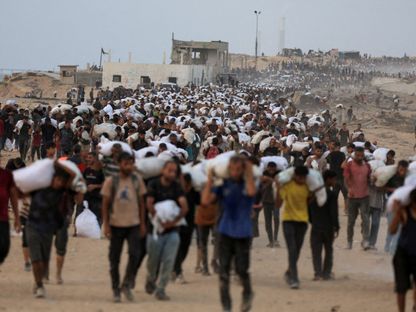 فلسطينيون يحملون مساعدات إغاثية في بيت لاهيا شمال قطاع غزة، 29 يوليو 2025 - REUTERS