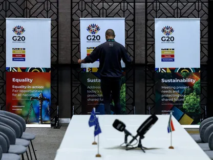 عامل يضع لافتات مجموعة العشرين في مكان اجتماع زعماء جنوب إفريقيا والاتحاد الأوروبي، قبل قمة مجموعة العشرين المقرر عقدها في جوهانسبرج، جنوب أفريقيا، 20 نوفمبر 2025. - REUTERS