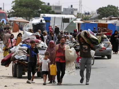 نازحون فلسطينيون يغادرون رفح سيراً على الأقدام ومعهم أمتعتهم بسبب الغارات الإسرائيلية، جنوب قطاع غزة. 28 مايو 2024 - reuters