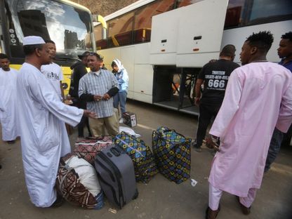 لاجئون سودانيون ينتظرون بجوار أمتعتهم في نقطة تجمع للحافلات بالقاهرة في طريق عودتهم الطوعية من مصر إلى السودان. 11 أبريل 2025 - REUTERS