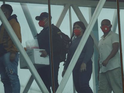 يحمل أحد أفراد جهاز المخابرات البوليفاري صندوقاً يحتوي على ملفات المهاجرين الفنزويليين أثناء وصول المهاجرين بعد ترحيلهم من الولايات المتحدة إلى مطار سيمون بوليفار الدولي في مايكيتيا بفنزويلا. 23 أبريل 2025 - REUTERS