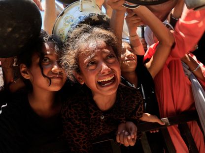 أطفال فلسطينيون ينتظرون الحصول على طعام من مطبخ خيري وسط أزمة جوع في خان يونس جنوبي قطاع غزة. 4 أغسطس 2025 - REUTERS