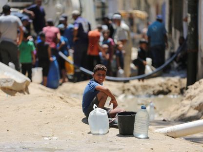 طفل فلسطيني أمام طابور في خان يونس للحصول على المياه وسط أزمة حادة في مياه الشرب النظيفة بقطاع غزة. 29 يوليو 2024 - Reuters
