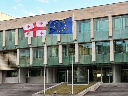 علما جورجيا والاتحاد الأوروبي يرفرفان في مقر جهاز أمن الدولة في تبليسي. 5 فبراير 2024 - AFP