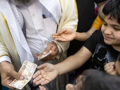 صورة تعبيرية عن توزيع العيدية على الأطفال - getty