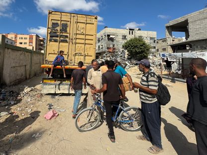 فلسطينيون في خان يونس يقفون خلف شاحنة محملة بجثث ضحايا الغارات الإسرائيلية. 25 سبتمبر 2024 - REUTERS