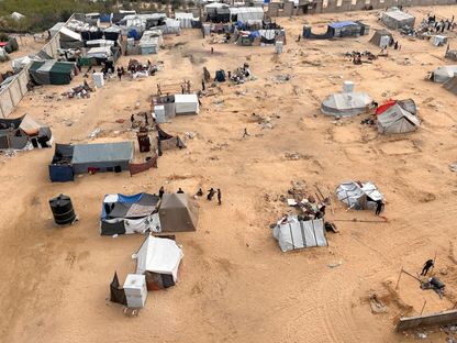 نازحون فلسطينيون يستعدون لإخلاء مخيم بعد أن شنت القوات الإسرائيلية عملية برية وجوية في الجزء الشرقي من رفح جنوب قطاع غزة. 11 مايو 2024 - REUTERS