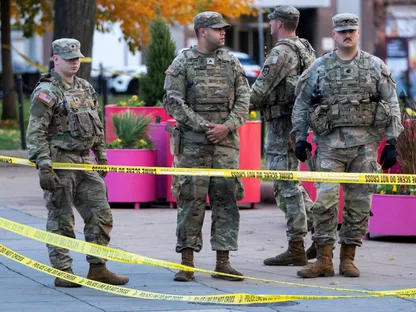 أعضاء الحرس الوطني يقفون خلف أشرطة صفراء في موقع إطلاق النار على اثنين من زملائهما بالقرب من البيت الأبيض في واشنطن العاصمة بالولايات المتحدة. 26 نوفمبر 2025 - REUTERS