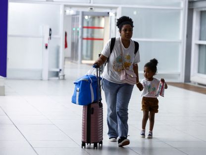 امرأة وطفلة، من بين المواطنين الفرنسيين الذين تم إجلاؤهم من النيجر، في مطار شارل ديجول في باريس، فرنسا، 2 أغسطس 2023 - Reuters