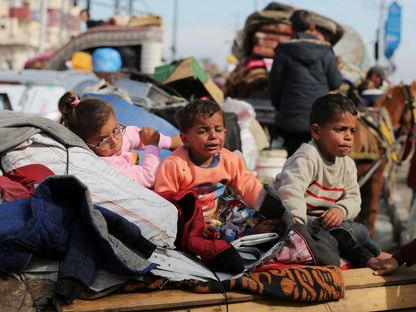 أطفال فلسطينيون ينتظرون في وسط قطاع غزة السماح لهم بالعودة إلى ديارهم في شمال القطاع. 26 يناير 2025. - REUTERS