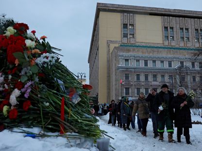 مواطنون روس يسيرون لوضع الزهور على نصب حجر سولوفيتسكي لضحايا القمع السياسي تكريماً لذكرى زعيم المعارضة  أليكسي نافالني الذي توفي بشكل مفاجئ في أحد سجون البلاد. 17 فبراير 2024 - Reuters