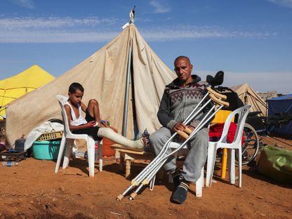 مواطن مغربي وابنه المصاب يجلسان خارج خيمتهما، وكلاهما أصيبا في أعقاب الزلزال الذي ضرب منطقة أمزميز بالمغرب. 17 سبتمبر 2023 - Reuters