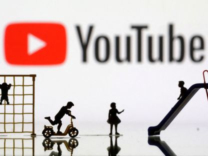 صورة تعبيرية لأطفال يلعبون أمام شعار منصة الفيديوهات "يوتيوب". 4 أبريل 2023 - REUTERS
