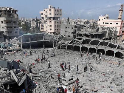 فلسطينيون يتفقدون الأضرار التي لحقت بمدرسة دار الأرقم بعد تعرضها لغارة إسرائيلية، مدينة غزة. 4 أبريل 2025 - Reuters