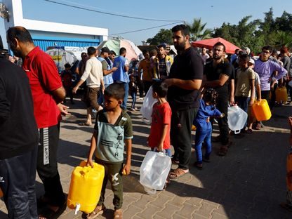 نازحون فلسطينيون يصطفون للحصول على المياه بمخيم الأمم المتحدة للاجئين في خان يونس.  26 أكتوبر 2023 - Reuters