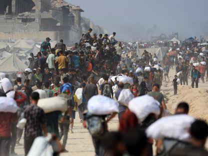 فلسطينيون يحملون مساعدات حصلوا عليها من شاحنات دخلت غزة في بيت لاهيا بشمال قطاع غزة. 10 أغسطس 2025 - Reuters