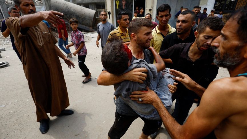 فلسطينيون يحملون أحد المصابين في غارة جوية إسرائيلية استهدفت مدينة غزة. 12 أغسطس 2025 - REUTERS