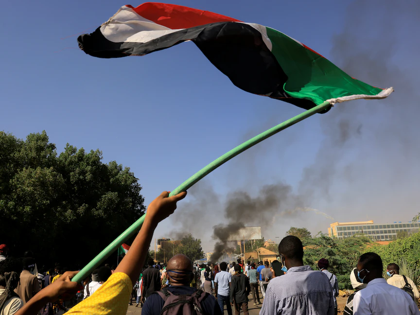 متظاهر في العاصمة الخرطوم يرفع علم السودان - 9 يناير 2022 - REUTERS