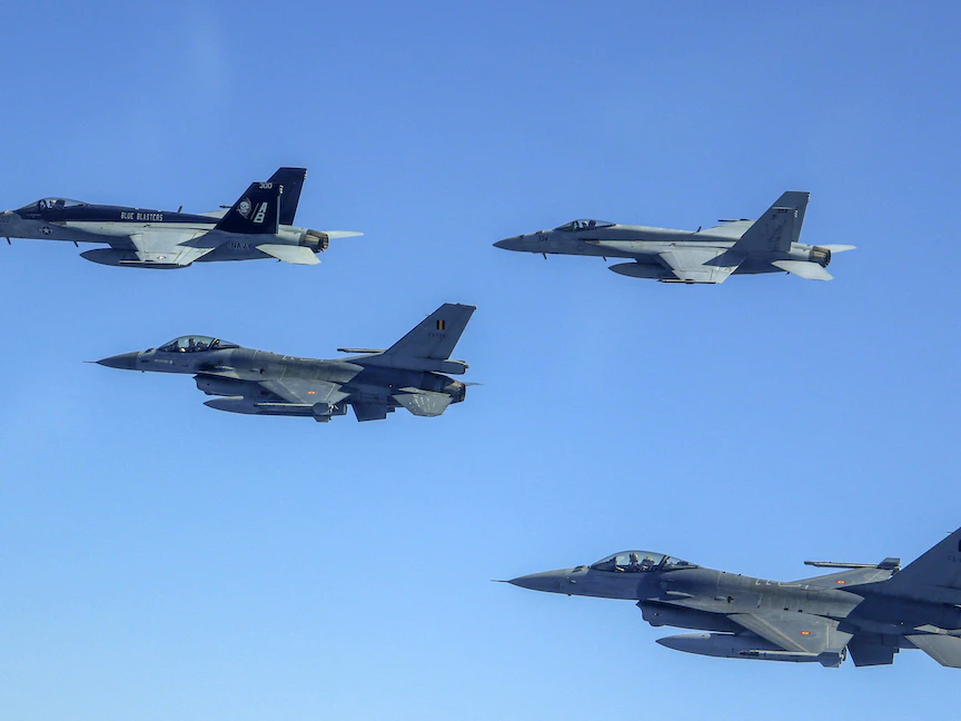 مقاتلة "إف / إيه-18سوبر هورنيت" تابعة للبحرية الأميركية وطائرات "F 16" تابعة لسلاح الجو البلجيكي تحلق فوق البحر الأبيض المتوسط. 25 يوليو 2022 - AFP