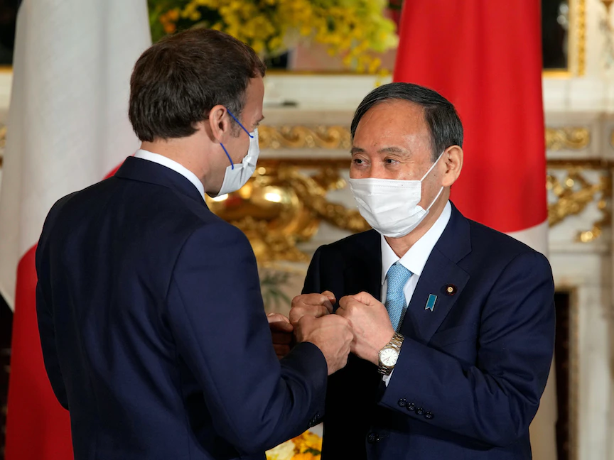 الرئيس الفرنسي إيمانويل ماكرون ورئيس الوزراء الياباني يوشيهيدي سوغا، خلال لقائهما في العاصمة البابانية طوكيو - 24 يوليو 2021 - REUTERS