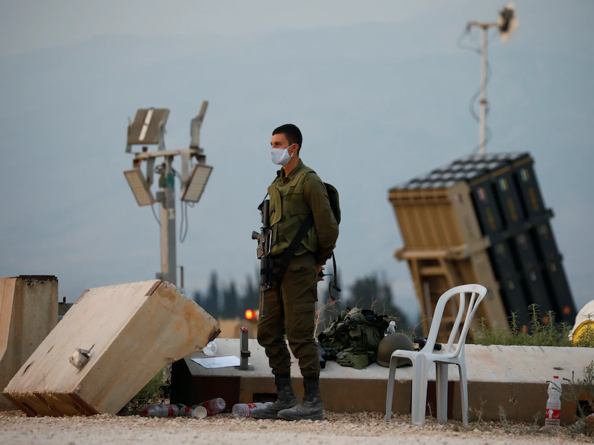 جندي إسرائيلي يقف قرب نظام القبة الحديدي، المضاد للصواريخ على الحدود الشمالية مع لبنان - REUTERS