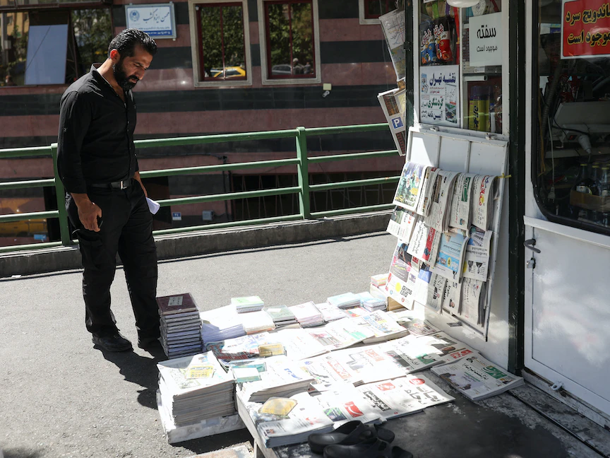 رجل يشاهد الصحف في العاصمة الإيرانية طهران - 16 أغسطس 2022 - via REUTERS