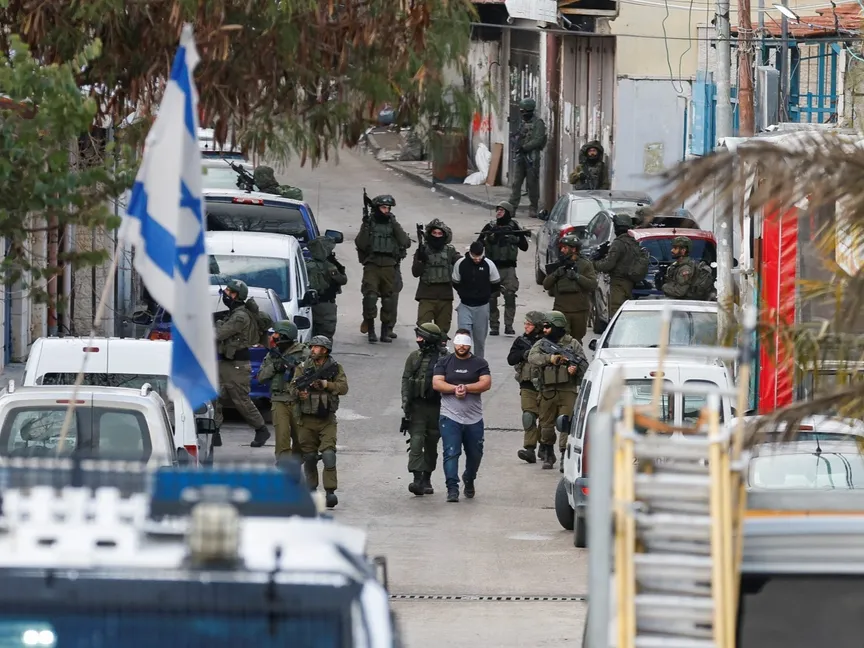 جنود إسرائيليون يحتجزون فلسطينيين خلال مداهمة في رام الله بالضفة الغربية. 4 مارس 2024 - REUTERS