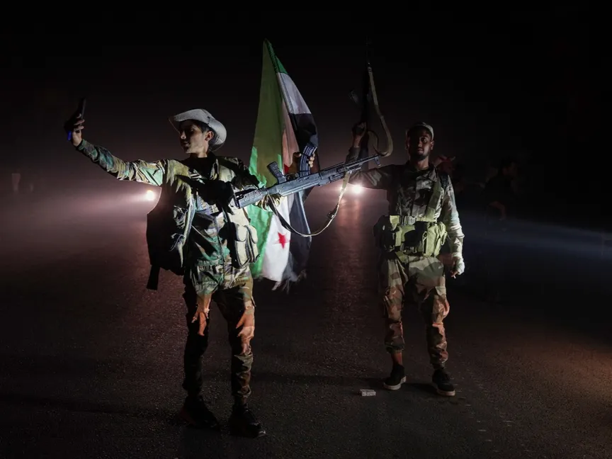 أفراد من الأمن السوري يقفون على طريق في ريف السويداء بينما تنقل مركبات التي تنقل قوات الجيش للخروج من المدينة ذات الأغلبية الدرزية، سوريا. 16 يوليو 2025 - REUTERS