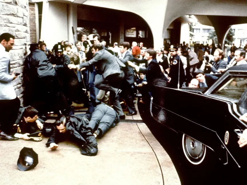 أفراد الشرطة وعملاء الخدمة السرية يلقون القبض على جون هينكلي بعد محاولة اغتيال الرئيس الأميركي آنذاك رونالد ريجان. 30 مارس 1981 - AFP