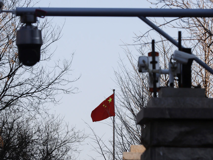 علم الصين بالقرب من كاميرات مراقبة خارج محكمة في العاصمة بكين. 31 مارس 2022 - REUTERS