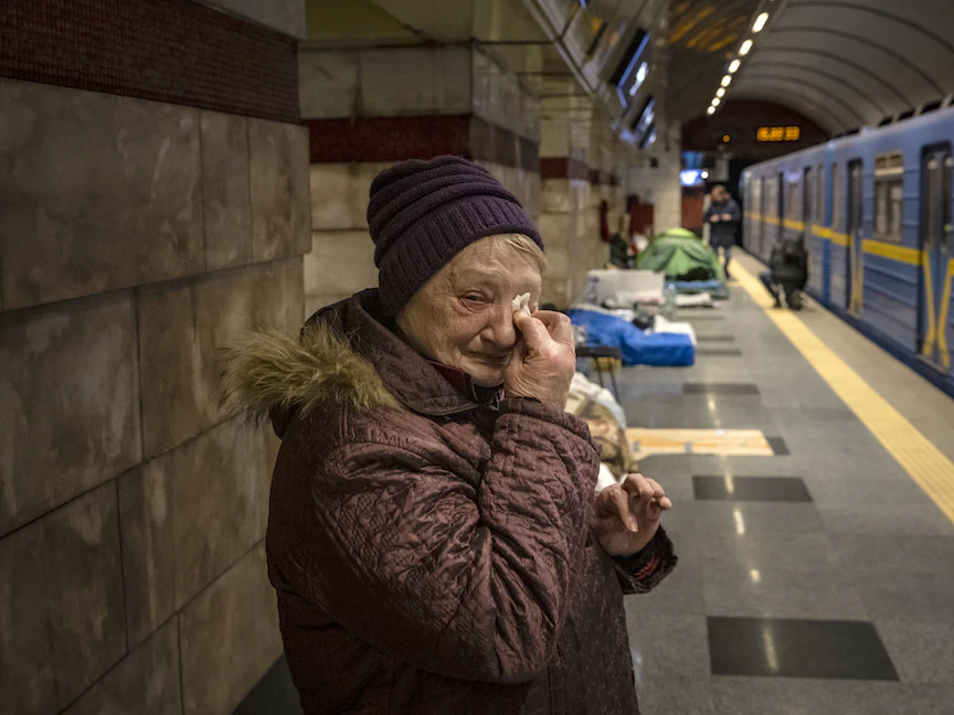 أوكرانية مسنّة تبكي خلال وجودها في إحدى محطات المترو في كييف هرباً من الحرب- 18 مارس 2022. - AFP