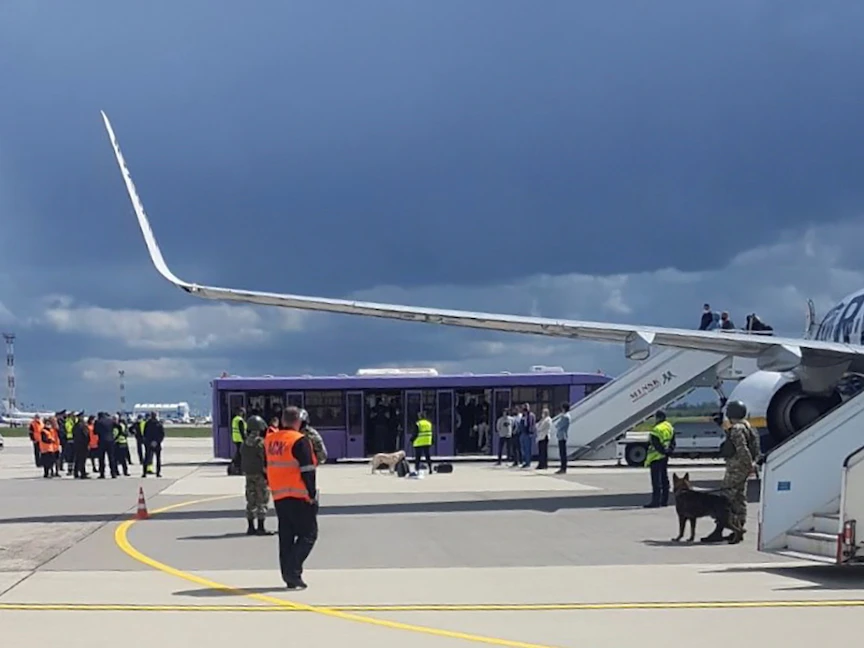 موظفون ورجال أمن على مدرج مطار مينسك أمام طائرة "راين إير" التي أُرغمت على الهبوط في بيلاروسيا، 23 مايو 2021 - REUTERS