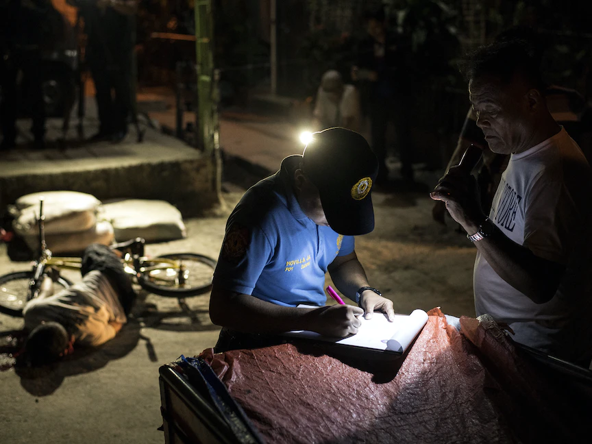 جثة متهم بالاتجار في المخدرات ملقاة على الأرض بعد أن قتله مهاجم مجهول في مانيلا، 23 مارس 2018 - AFP