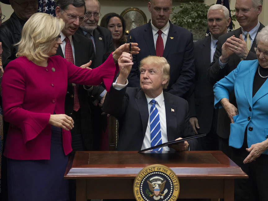 الرئيس الأميركي السابق دونالد ترمب، يهدي النائبة الجمهورية ليز تشيني قلماً وقع به مشروع قانون - البيت الأبيض، واشنطن دي سي - 27 مارس 2017 - AFP