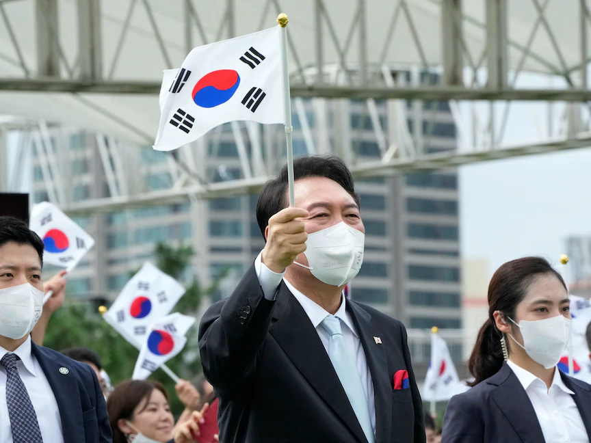 الرئيس الكوري الجنوبي يون سوك يول يلوّح بعلم بلاده في سول خلال احتفال بيوم التحرير من الاستعمار الياباني. 15 أغسطس 2022 - REUTERS