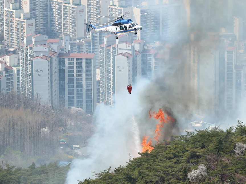 طائرة هليكوبتر تسقط الماء على حريق في جبل إنوانج في العاصمة سول، كوريا الجنوبية - 2 أبريل 2023 - via REUTERS