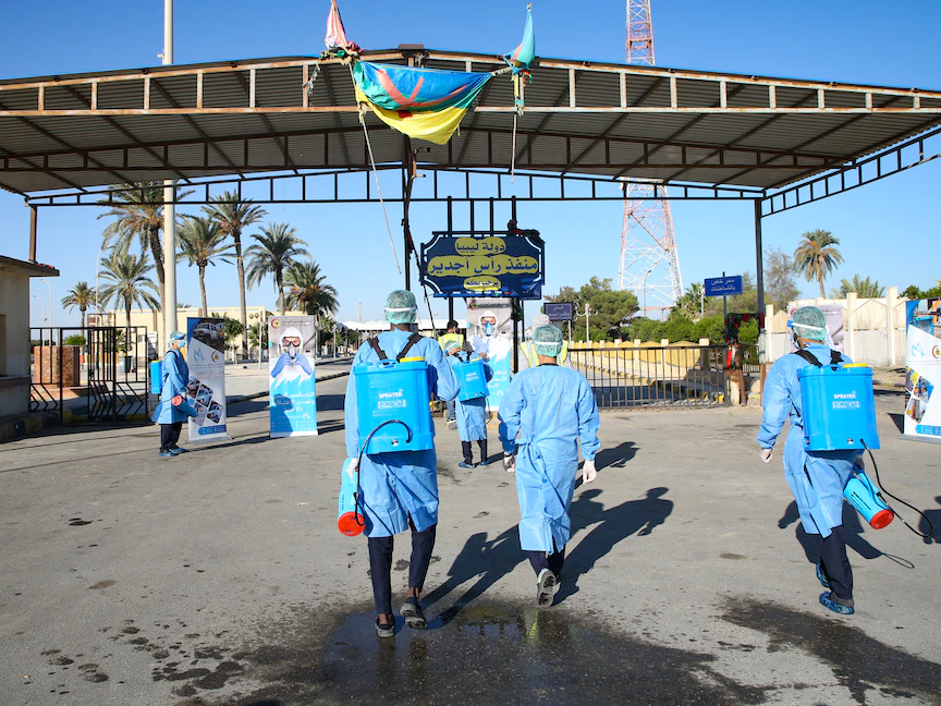 عمال ليبيون في منفذ رأس جدير الحدودي بين ليبيا وتونس، يقومون بعمليات تطهير، 14 نوفمبر 2020 - AFP