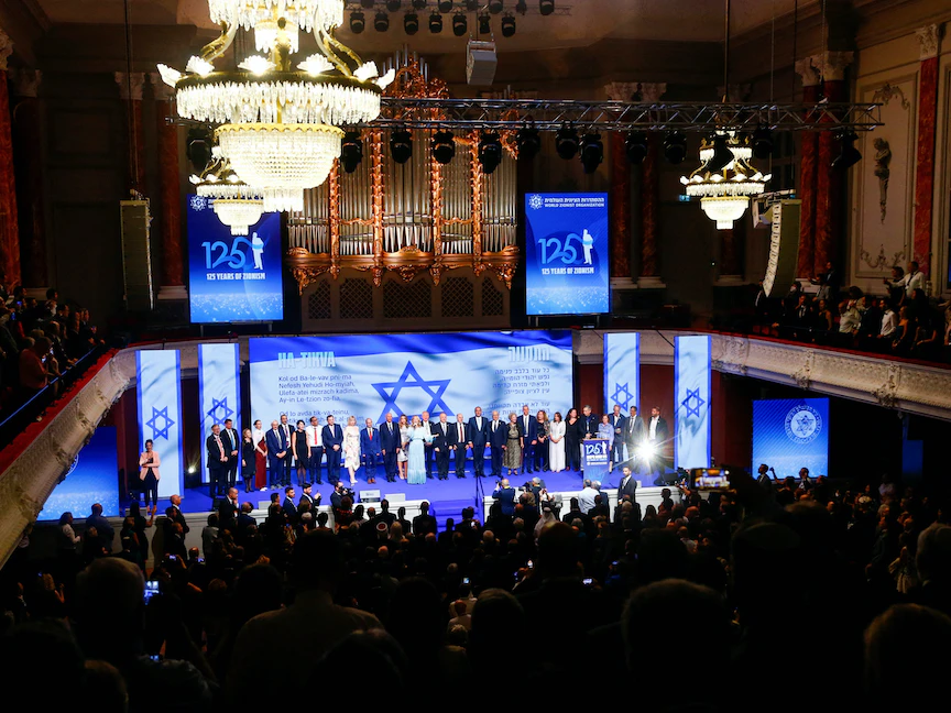 المشاركون في الاحتفال الذي أقيم بمناسبة الذكرى 125 لانعقاد المؤتمر الصهيوني الأول ينشدون النشيد الوطني الإسرائيلي. بازل، سويسرا. 22 أغسطس 2022 - REUTERS