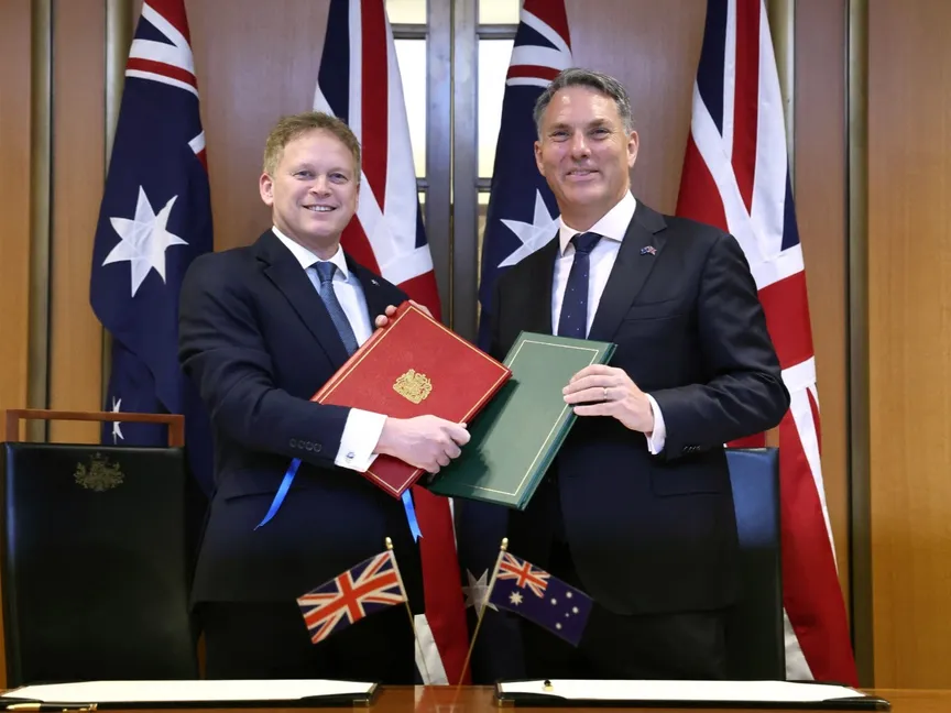 وزير الدفاع الأسترالي ريتشارد مارليس (يمين) ونظيره البريطاني جرانت شابس خلال مراسم توقيع الاتفاقية في البرلمان بالعاصمة كانبرا. 21 مارس 2024 - AFP