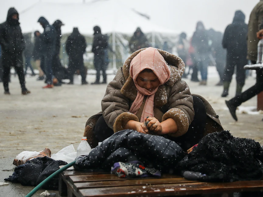 امرأة تغسل ملابسها في منطقة غرودنو بالقرب من الحدود البيلاروسية البولندية- 23 نوفمبر 2021 - REUTERS