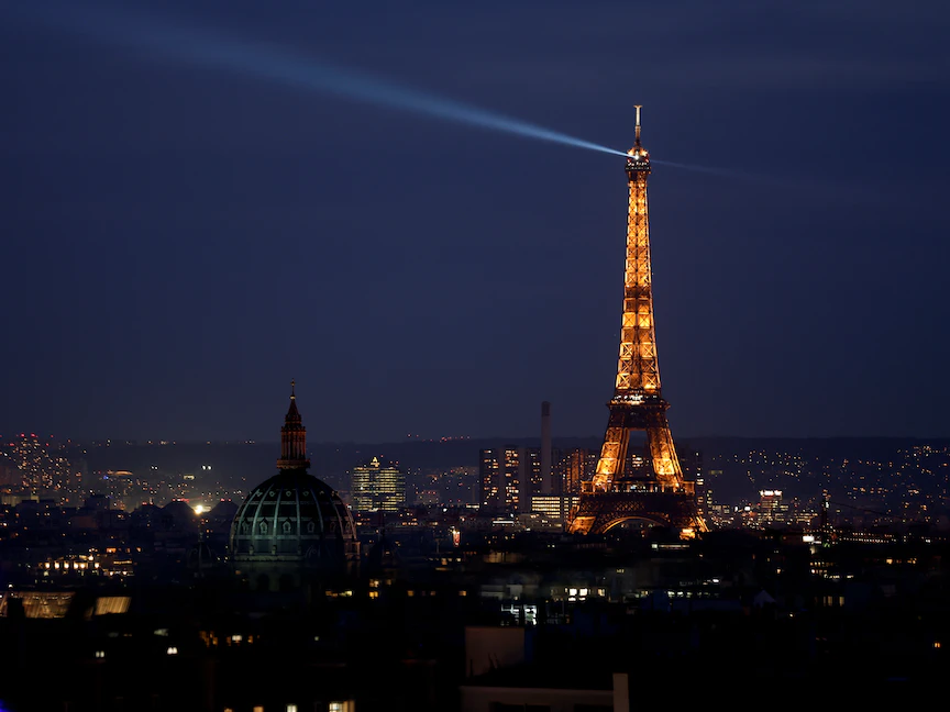 برج إيفل في العاصمة الفرنسية باريس أثناء إضاءته ليلاً بأنوار خافتة - 9 مارس 2022 - REUTERS