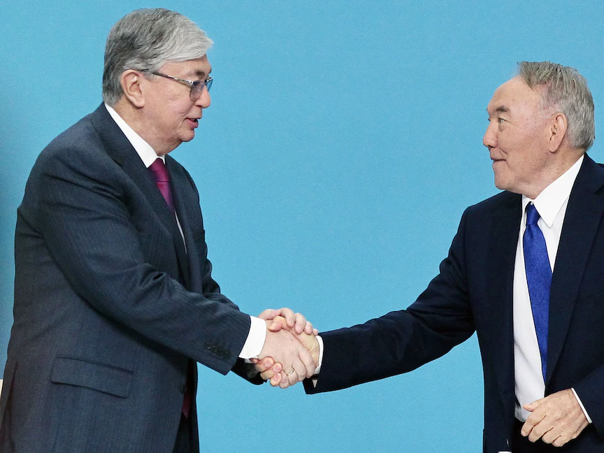 الرئيس الكازاخي السابق نور سلطان نزارباييف يصافح الرئيس قاسم جومارت توكاييف خلال مؤتمر لحزب نور أوتان الحاكم في مدينة نورسلطان - 23 أبريل 2019 - AFP