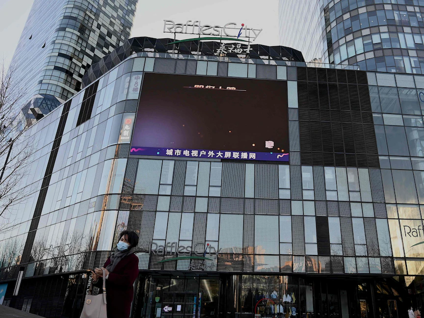 امرأة تمشي أمام مركز التسوق Raffles City المغلق في بكين - 11 نوفمبر 2021 - AFP