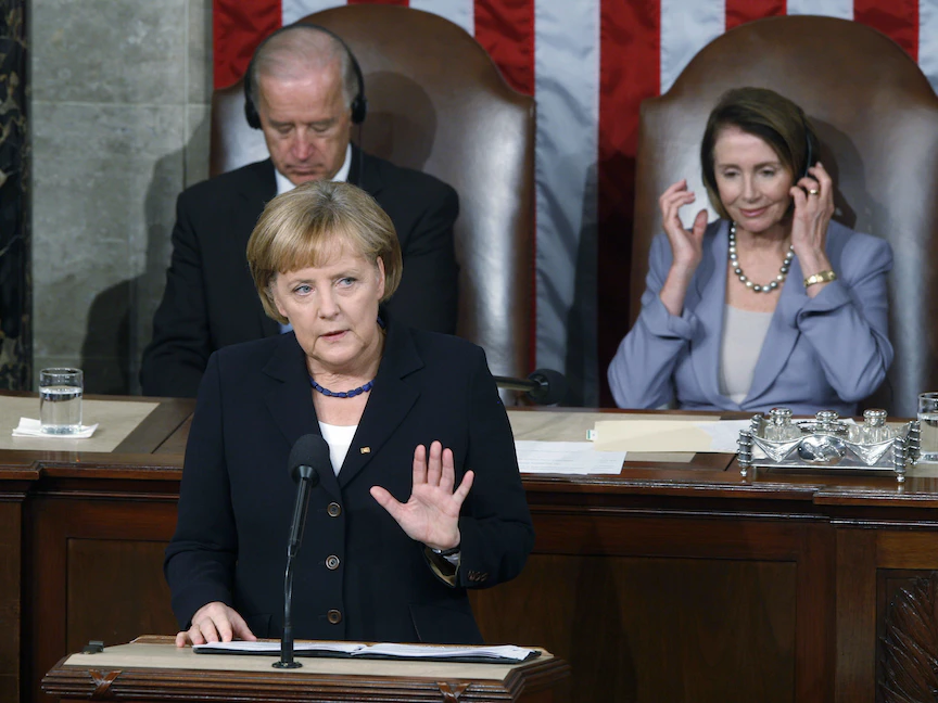 صورة أرشيفية للمستشارة الألمانية أنجيلا ميركل تلقي خطاباً في الكونجرس الأميركي، ووراءها جو بايدن حين كان نائباً للرئيس الأميركي باراك أوباما، ورئيسة مجلس النواب نانسي بيلوسي- 3 نوفمبر 2009 - REUTERS