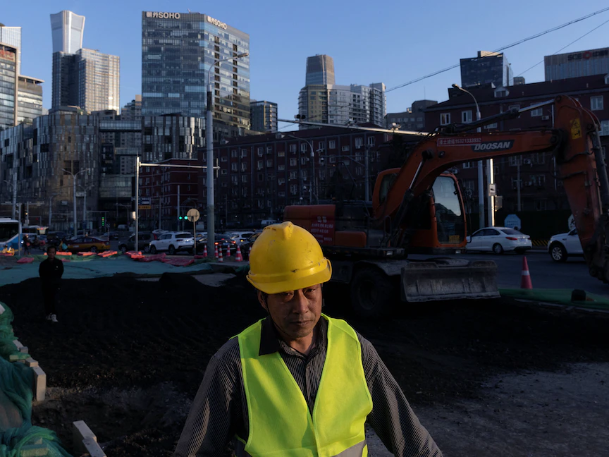 عامل يمشي قرب موقع بناء في بكين. 28 فبراير 2023 - REUTERS