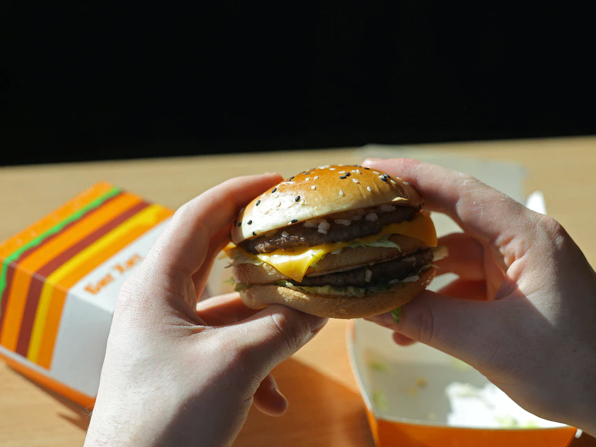 رجل يمسك شطيرة هامبرجر في أحد مطاعم الوجبات السريعة في موسكو، روسيا - REUTERS