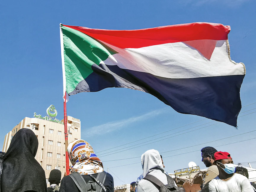 متظاهرون يحملون علم السودان في العاصمة الخرطوم - 4 يناير 2022 - AFP