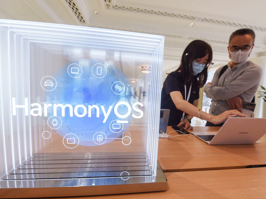 بعض المستخدمين يجربون نظام هواوي الجديد HarmonyOS عبر بعض أجهزتها في أحد فروعها في شنغهاي - AFP