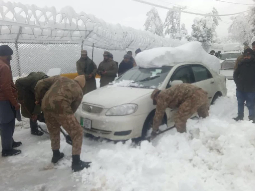 قوات من الجيش الباكستاني تشارك في عملية تنظيف طريق مغطى بالثلوج في مدينة موري التي تبعد 70 كيلومتراً عن العاصمة - 8 يناير 2022 - AFP